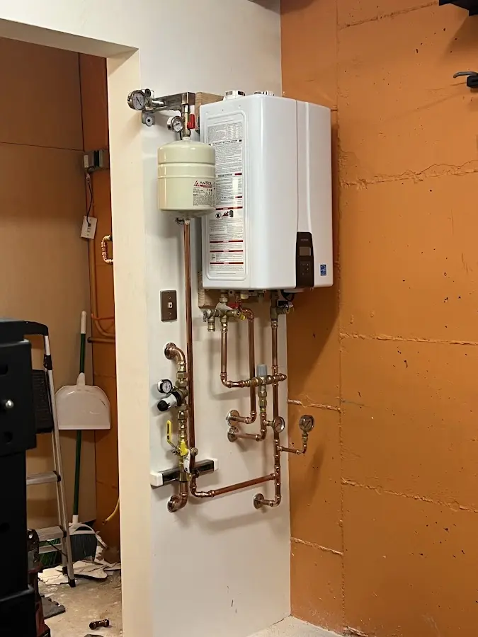 Plumbing technician inspecting water heater connections in Susquehanna